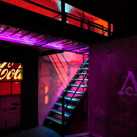 Treppe im rosarot ausgeleuchteten Arena Club mit grün beleuchteten Stufen