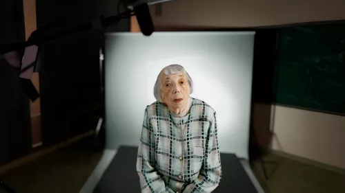 Volumetrisches Abbild der Holocaust-Überlebenden Margot Friedländer in einem Klassenzimmer. 