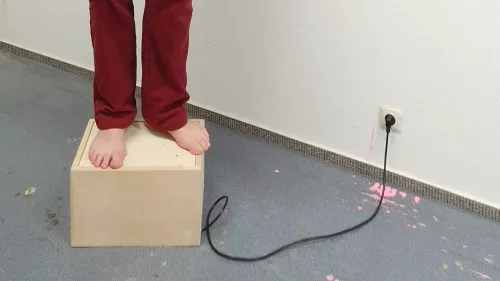 Füsse stehen auf einer Holzkiste.
