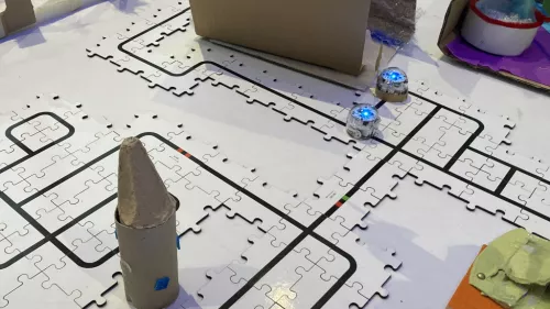 Kleine Roboter fahren auf schwarzen Linien.