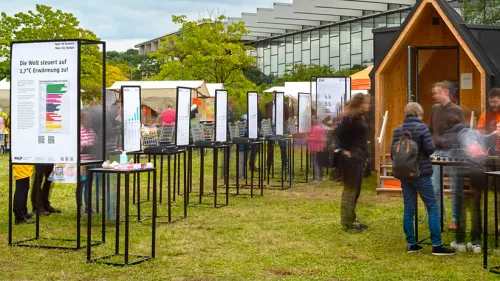 Menschen vor Spiel mit Grenzen Infotafeln in der Natur.
