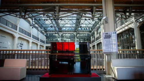 Ein Yamaha MIDI Klavier steht auf dem Musikbalkon des ZKM | Zentrum für Kunst und Medien - einer alten Munitionsfabrik, die zu einem Kulturort umgebaut wurde. Rotes Licht spiegelt sich im schwarzen Lack des Klaviers.