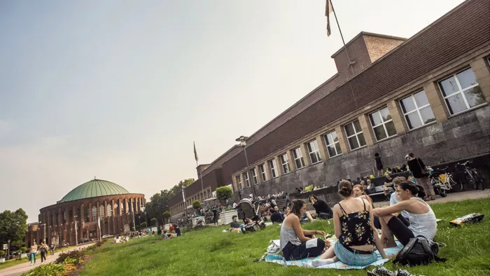 Menschen sitzen auf einer Picknickdecke auf einer Wiese