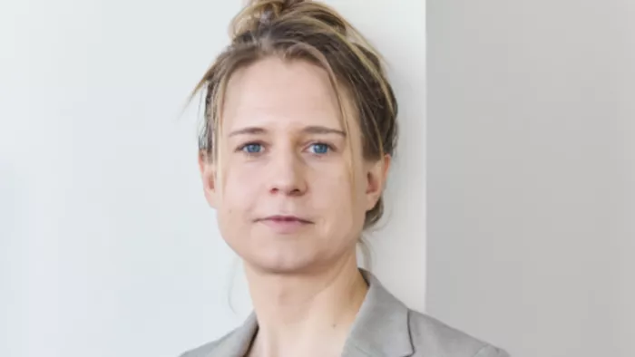 Foto von Maren Urner. Sie schaut direkt in die Kamera und trägt einen Blazer und ihre Haare in einem Dutt.