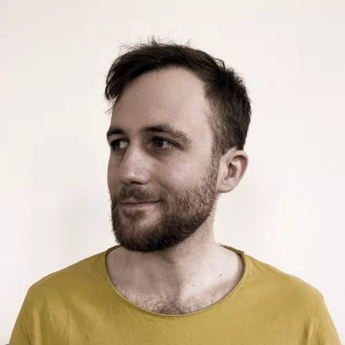 Daniel in gelbem Shirt, schaut links vorbei an der Kamera
