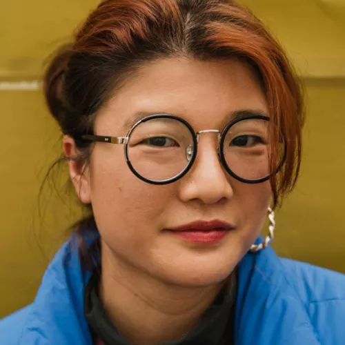 weibliche Person mit Brille und zusammengebundenen Haaren