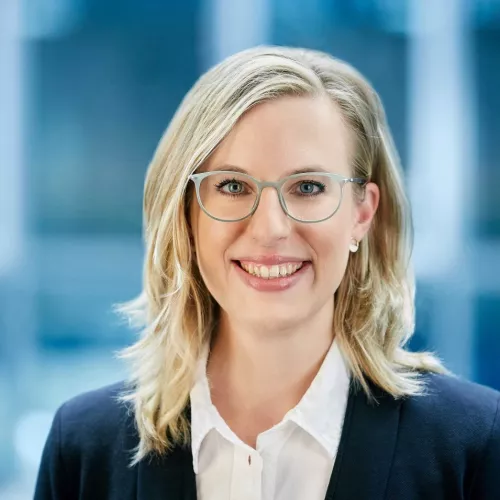 Blonde Frau mit Brille und Business-Look