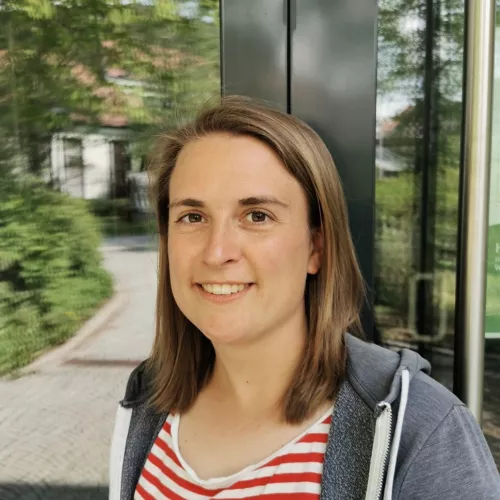 Svenja steht vor reflektierenden Drehtür