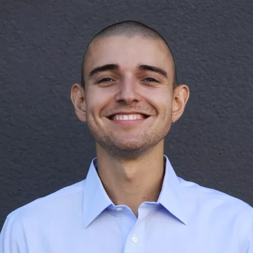 male, 28 years old, blue shirt, buzz cut
