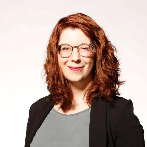 Halbportraitbild von Bianka Bunde in mintgrüner Bluse und schwarzem Blazer, die in die Kamera schaut und lächelt.