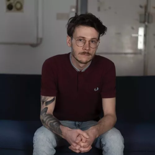 Sören Musyal sitzt auf einer Couch