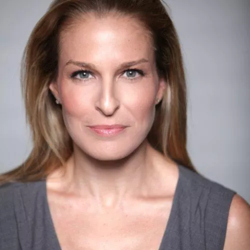 Danna Stern schaut in ihrem Portrait direkt in die Kamera. Sie trägt lange blonde Haare und ein graues Oberteil/Kleid.