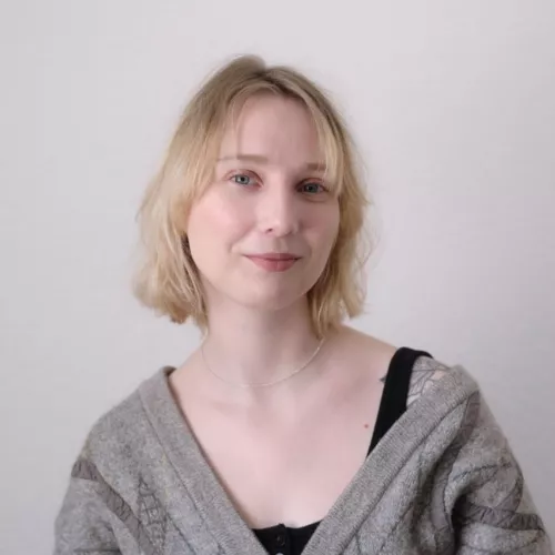 Eine blonde Frau lächelt in die Kamera
