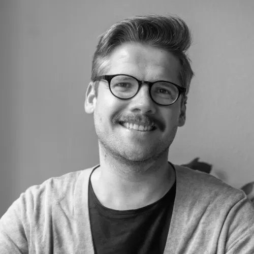 Foto in Schwarz-Weiß von einer männlichen Person mit Brille