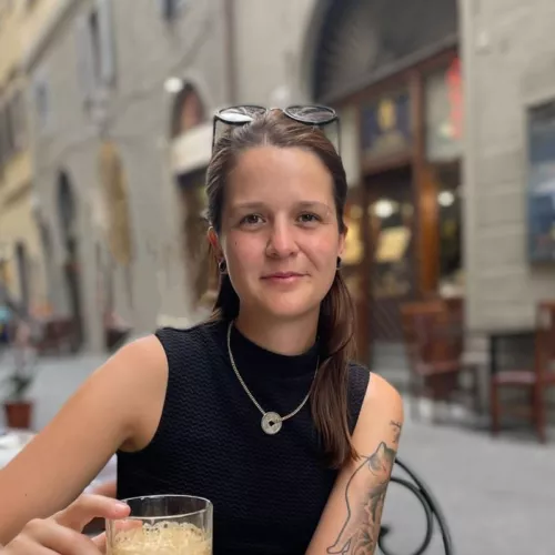Jana Steuer sitzt am Tisch eines Cafés vor einer Tasse Kaffee