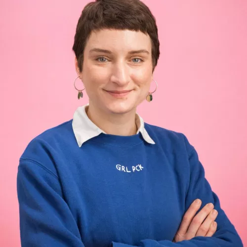 Weibliche Person mit kurzen Haaren und blauem Pullover 