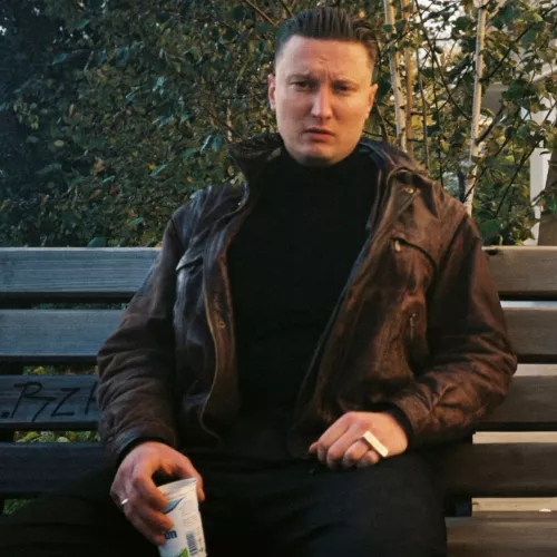 Filatow sitz auf einer Bank und trinkt einen Ayran. 
