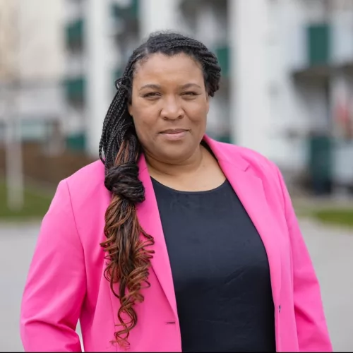 Portrait Doreen Denstädt vor einem Alt-Neubau-Block