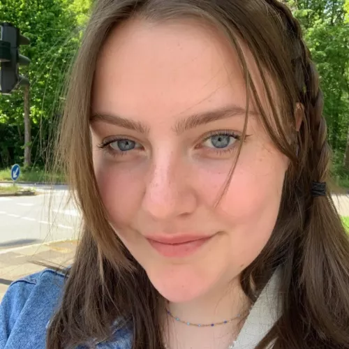 Katleen Schnell lächelt in die Kamera, hat blaue Augen und braune, lange Haare. 