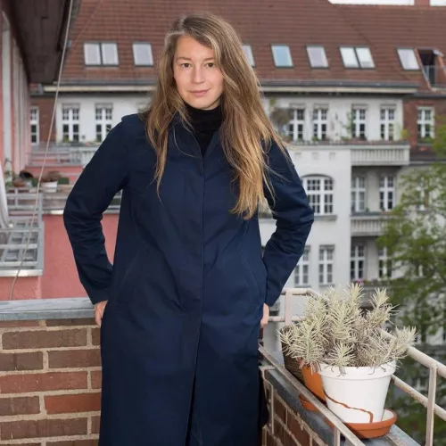 Porträt auf einem Balkon - Im Hintergrund ein Häuserdach