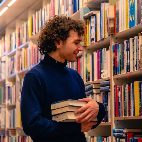 Josia Jourdan vor Bücherregal im Seitenprofil