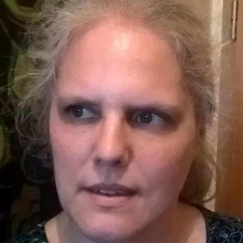 Gesicht Frau mit zurückgekämmten Haaren und Bluse; schaut zur Seite