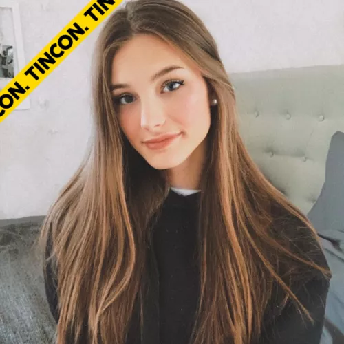 Katulka lächelt in die Kamera. Sie hat offene braune lange Haare und trägt einen schwarzen Pulli. 