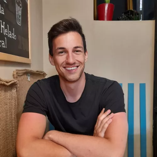 Leo Braun sitzt am Tisch und lächelt
