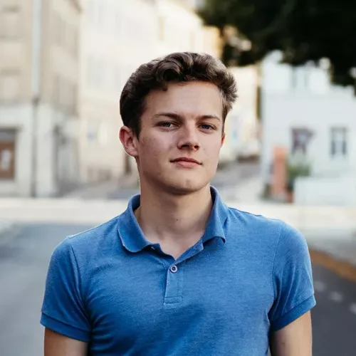 Max Hilse im Hintergrund helle Stadtkulisse. 