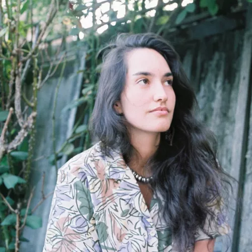 Bild von Michelle Brand mit farbenfroher, abstrakter Bluse.