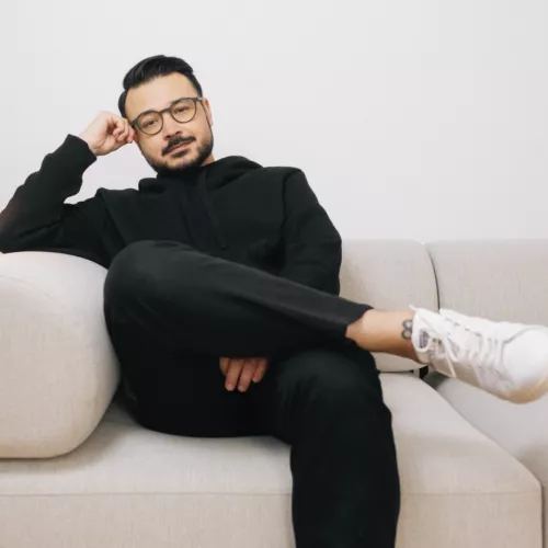 Das Foto zeigt den Psychotherapeuten Umut Özdemir sitzend auf einem Sofa