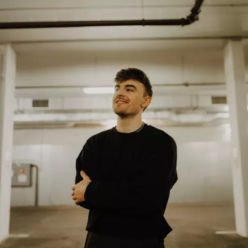 Foto eines jungen Mannes, der in einer Tiefgarage steht