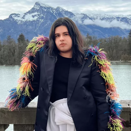 An image of a person wearing a coat with colored feathers.