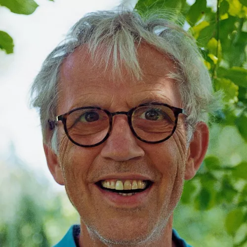 Offener Blick mit Lachfalten, graue Haare und Brille