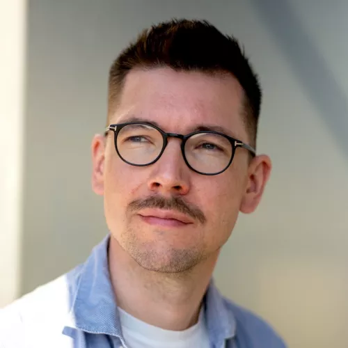Foto eines weißen Mannes mit Brille und kurzen Haaren