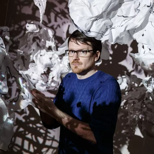 Portrait of Robert Seidel setting up the video installation "tearing shadows"