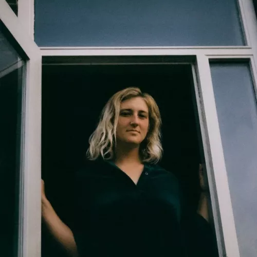 Irma standing in doorway, smiling softly.