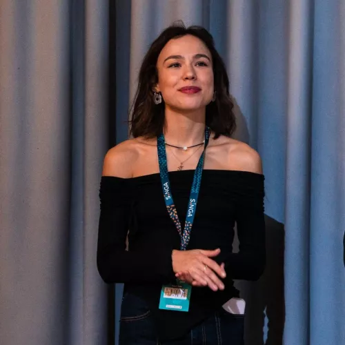 Frau in schwarzer Kleidung bei einem Vortrag auf einer Konferenz.