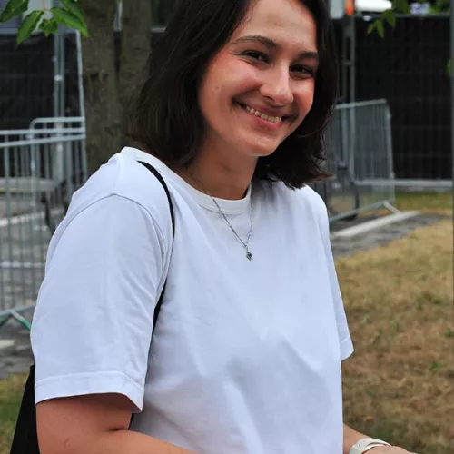 Frau mit mittellangen schwarzen Haaren und weißem Tshirt