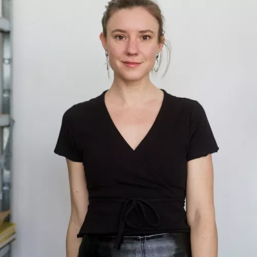Professional frontal 3/4 portrait photo of a woman, wearing a black T-Shirt and a black skirt. Photo: Simon Oberhofer