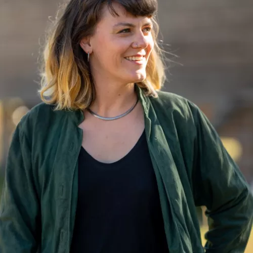 Eine Person in grüner Jacke, die nicht direkt in die Kamera schaut.