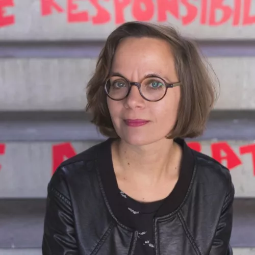 Eine Frau sitzt auf einer Treppe. An die Stufen der Betontreppe ist in Rot "responsibility" geschrieben. 