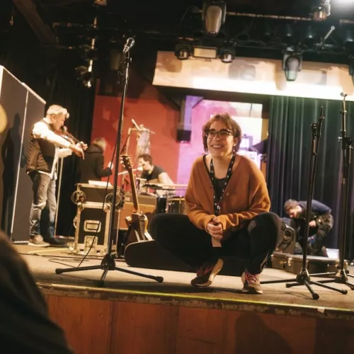 Anita on a stage with some musicians behind