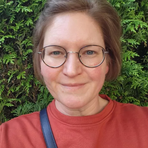 Auf dem Foto ist eine Frau mit Brille 
