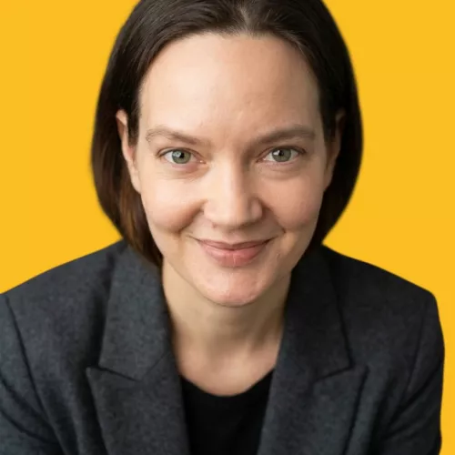 A headshot of Magda Sokolovic smiling to the camera, with a yellow background