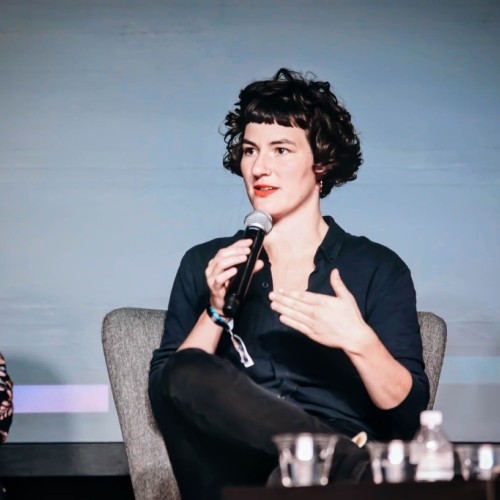 Photo shows Marie Bröckling on the stage of the re:publica conference Detroit with a microphone in hand.