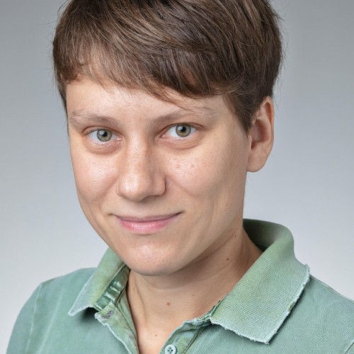 A short haired person in a green polo shirt