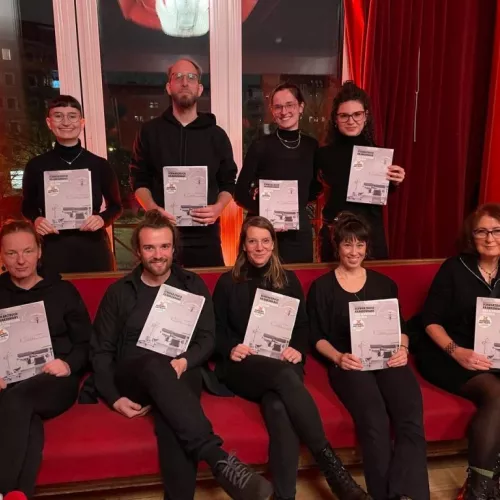 Gruppenfoto von Lesenden der Schwarzbuch Krankenhaus Texte, 9 Menschen, alle halten das Schwarzbuch in der Hand.